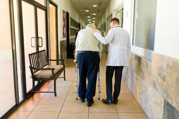 Male Good Doctor Seen Helping Mature Old Patient While Walking —  Fotos de Stock