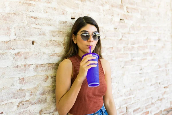 夏の屋外で過ごす間 おいしい冷たい飲み物を飲むサングラスを持つ魅力的なラテンの若い女性の肖像画 — ストック写真
