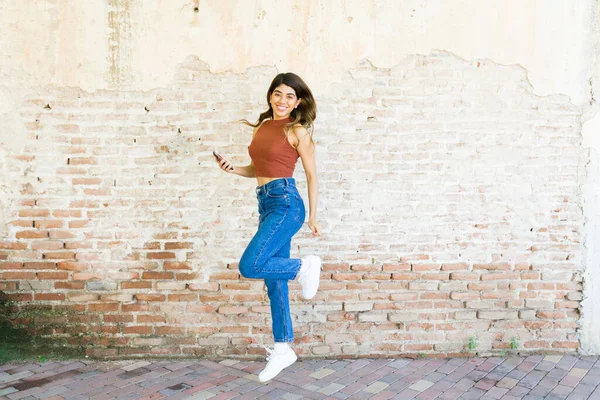 Cheerful Gorgeous Latin Woman Jumping Having Fun While Holding Her — Stock Photo, Image