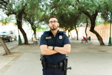 Beyaz tenli güçlü polis memuru kanun ve nizamın bir parçası olarak şehir parkında adaletsizliği ve suçu önlüyor.
