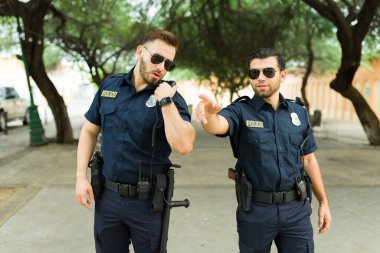 Beyaz polisler görev başında. Polis merkezine telsiz mesajı gönderiyorlar. Şehirde bir suçlu zanlıyı araştırıyorlar.