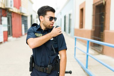 Çekici bir polis memuru, görevde olan bir şüpheli hakkında radyoda bir rapor hazırlıyor.