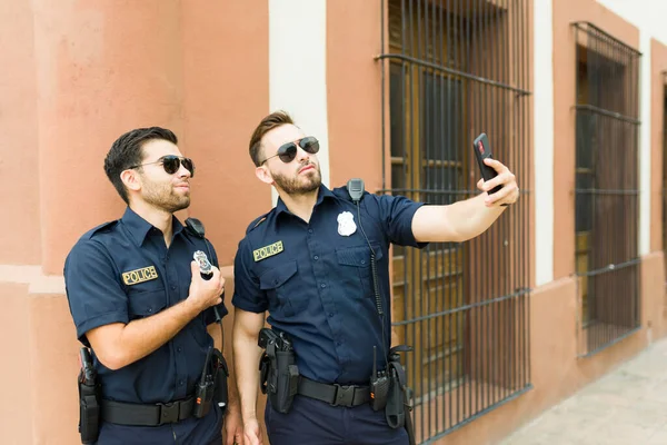 Atraktivní Policisté Službě Usmívají Vypadají Šťastně Venku Přičemž Selfie Chytrým — Stock fotografie