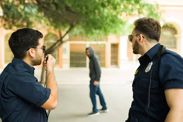 正在执行法律的白人警察在寻找犯罪嫌疑人时向警察局作电台报道 — 图库照片