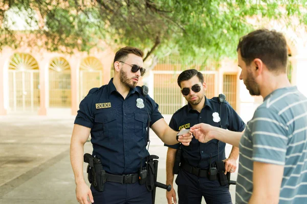 Kavkazský Policista Jeho Partner Hovoří Mladým Mužem Nebo Podezřelým Při — Stock fotografie