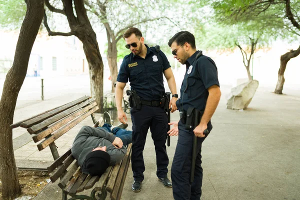 Policisté Službě Mluví Bezdomovcem Spícím Parku Lavičce — Stock fotografie