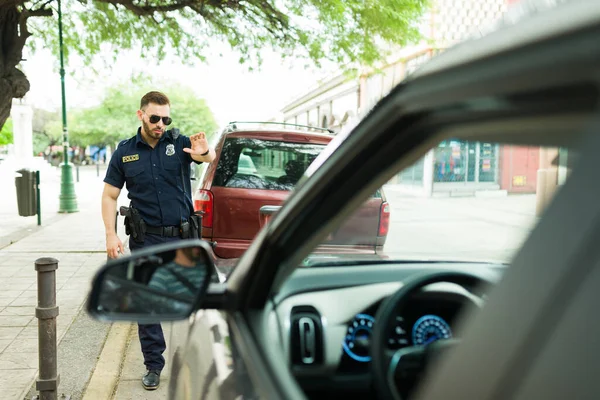 경찰은 주차를 딱지를 배달하기 손으로 운전하는 운전자에게 멈추는 몸짓을 — 스톡 사진