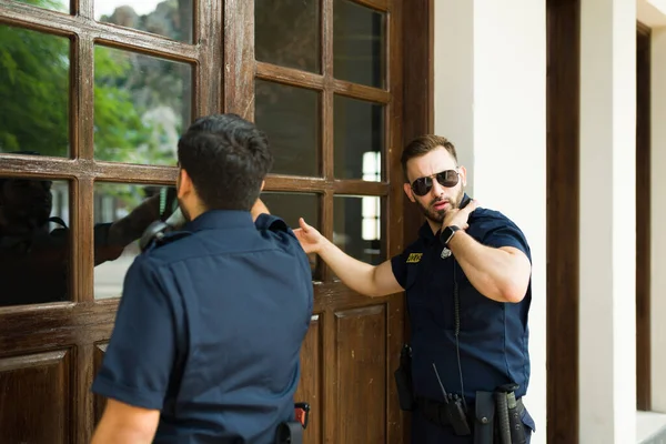Beyaz erkek polis, soruşturma yapmak ve suç delillerini aramak için arama emriyle evin kapısını çalıyor.