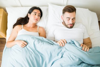 Yataktaki stresli beyaz adam partneriyle seks yaparken iktidarsızlık ya da ereksiyon sorunu yaşıyor.