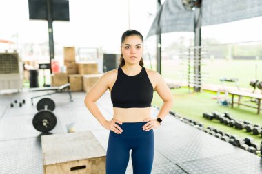 30 'lu yaşlarda güzel bir kadın aktif giyinmiş kameraya bakıyor egzersiz için hazırlanıyor.