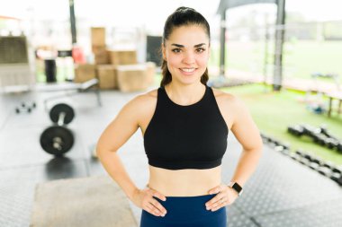 Gülümseyen ve mutlu görünen neşeli aktif bir kadın. Çapraz antrenmanlara ya da spor salonundaki egzersizlere başlamadan önce.
