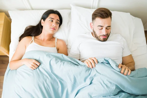 Stressed concerned caucasian man in bed having problems of impotence or erectile dysfunction while trying sex with his partner