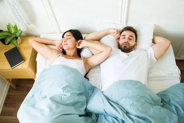 迷人的夫妻在睡了一个好觉后躺在床上舒展着身子 早上感觉到休息和放松 — 图库照片