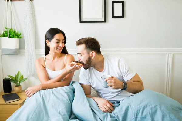 Feliz Joven Mujer Alimentando Donut Marido Compañero Mientras Desayuna Cama — Foto de Stock