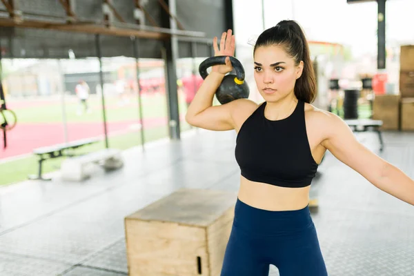 Aktivní Mladá Žena Hledá Odhodlaný Při Cvičení Pomocí Kettlebell Hmotnosti — Stock fotografie