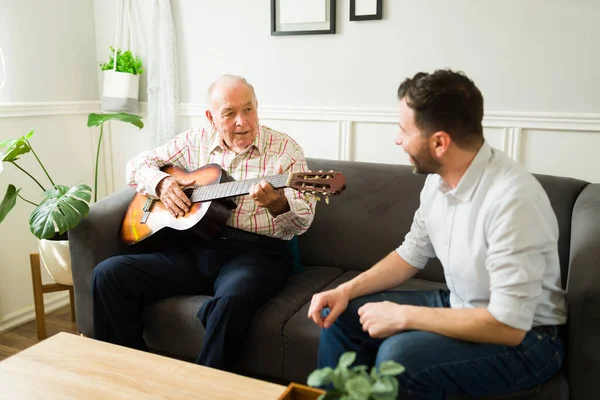 Ηλικιωμένος Γέρος Παίζει Κιθάρα Ενώ Τραγουδά Στο Γιο Του Χαλαρώνοντας — Φωτογραφία Αρχείου
