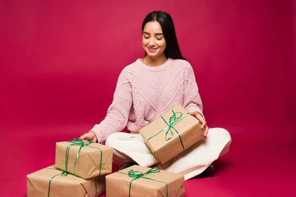 Hermosa Mujer Latina Sentada Frente Fondo Rojo Con Montón Regalos —  Fotos de Stock