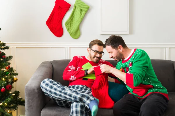 Çekici Beyaz Pijamalı Eşcinsel Çift Noel Çoraplarının Içindeki Hediyeleri Açıyor — Stok fotoğraf