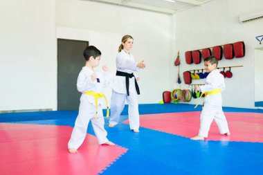 Tekvando okulunda dövüş sanatları yarışması düzenlerken çocuklarla karate antrenörü eğitimi.