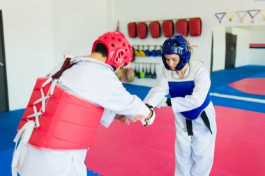 Sportmenlik kavramı. Tekvando dövüşçüleri dövüş sanatları ya da karate yarışmasını bitiriyor.