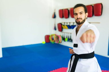 Güçlü çekici erkek dövüşçü tekvando ya da karate antrenmanında göz teması kuruyor.