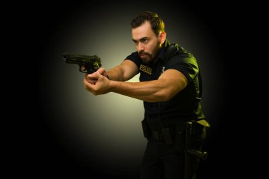 Görevdeki stresli polis memuru tutuklama sırasında silahını bir suçluya doğrultuyor. 