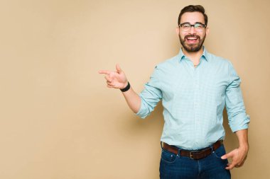 Mutlu beyaz adam, sarı arka planda fotokopi alanının yanına işaret ettiği için heyecanlı görünüyor.
