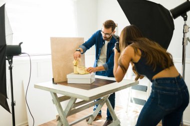 Stüdyoda moda fotoğrafı çekilirken profesyonel fotoğrafçılar ürün tasarımı yapıyor.