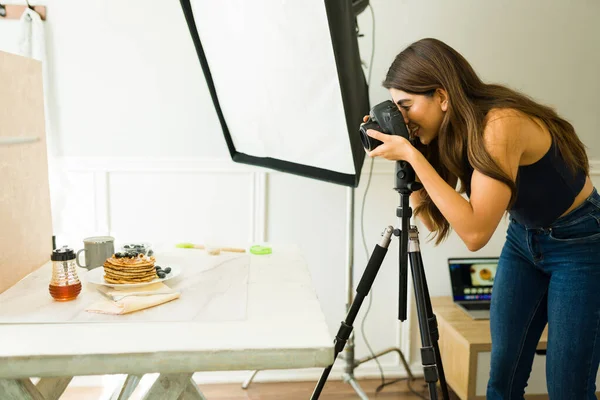 幸せな女性写真家は彼女のプロのスタジオで食べ物の写真撮影をしながら笑顔 — ストック写真