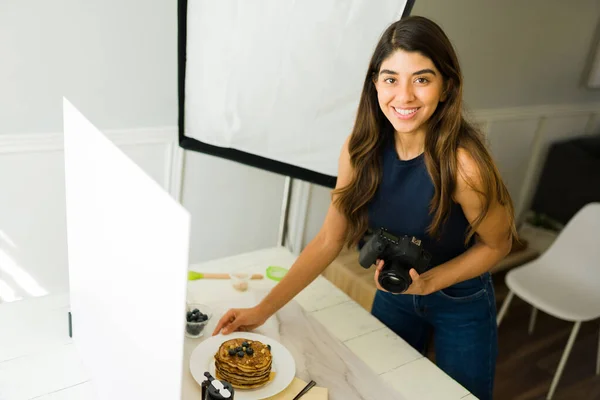 在拍摄过程中 拉汀的摄影师一边举着她的专业相机一边愉快地进行眼神交流和食物造型 — 图库照片