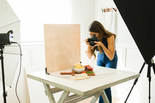 Latin food photographer doing a photo shoot at her professional studio with good lighting