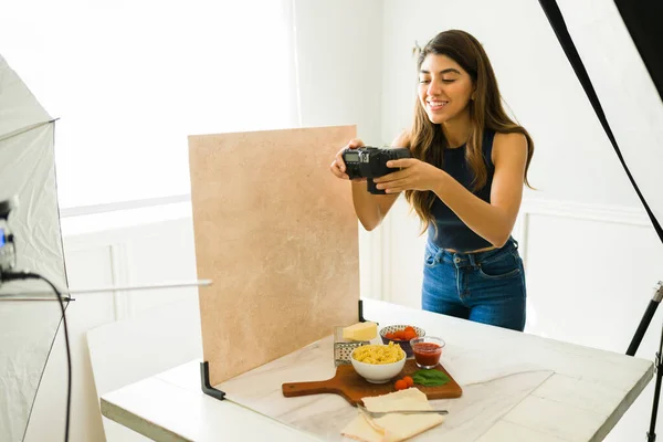 摄影棚里快乐的食品摄影师一边微笑 一边用专业相机拍照 — 图库照片