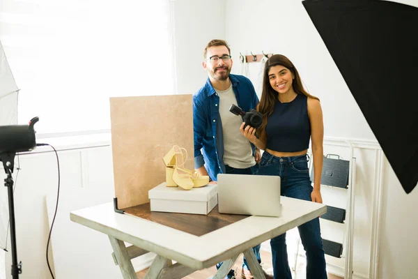 Portrait of happy young photographers smiling and looking at the camera while working at ther professional studio