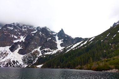 Sisli bir sabahta dağlarda göl manzarası