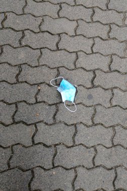 Kaldırımda tıbbi bir maske var. COVID-19 'un yayılmasıyla mücadele ediyoruz. Coronavirus salgını, yeni OMICRON damgası