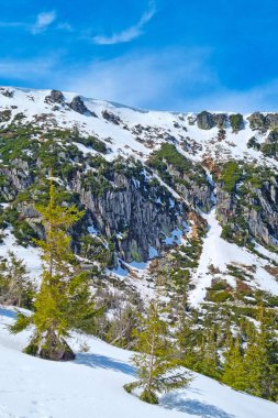 Güneşli bir günde ve mavi gökyüzünde karla kaplı dağın manzarası