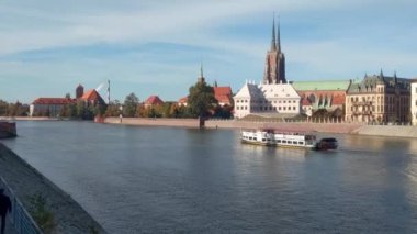 Wroclaw, Polonya, 15 Ekim 2021: Bir gemi nehir boyunca eski şehrin arka planına karşı yelken açar