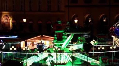 Wroclaw, Polonya, 23 Aralık 2021: Atlıkarıncalar akşam çalışır. Eski kasabanın ana meydanı. Noel Fuarı. Çocuklar ve yetişkinler için eğlence. Eğlence gezintileri