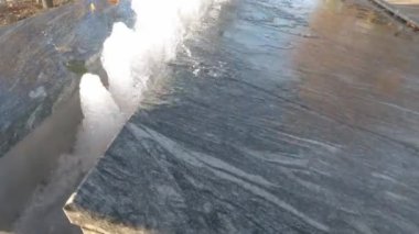 Su parktaki ocaktan aşağı akıyor. Sıcak bir yaz gününde çeşme.