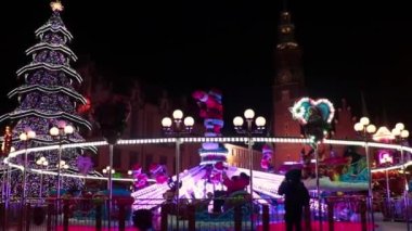 Wroclaw, Polonya, 22 Aralık 2021: Noel ve Yeni Yıl Fuarı sırasında şehir meydanında atlıkarınca, film tahılları
