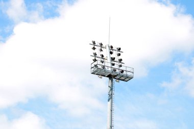 Mavi gökyüzüne karşı bir aydınlatma kulesi. Stadyum ışıklandırıcısı