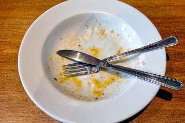 Yemekten sonra kirli beyaz çatal bıçak takımının üst görüntüsü