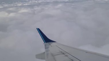 Uçan uçağın penceresinden manzara bulutlarda yüksekte.