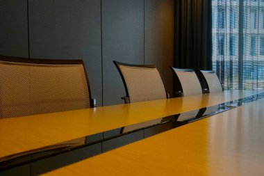 Ofisteki modern toplantı odası. Büyük masa ve sandalyeler.