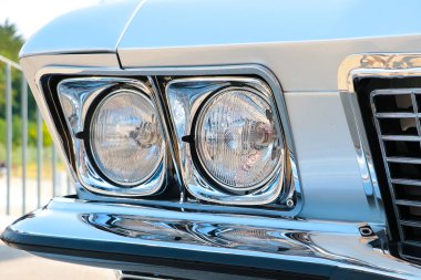 Eski bir arabanın tampon ve farlarını görüyorum.
