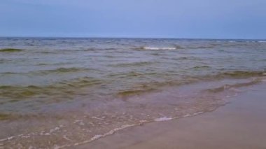 Deniz ya da okyanus manzarası çok güzel. Dalgalar kumlu kıyıya çarpar. Baltık Denizi sahili manzarası. Uzay plajı. Yaz günü deniz manzaralı bir yer. Deniz kumu ve kumsal gökyüzü