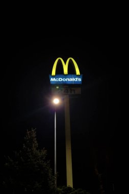 Wroclaw, Polonya, 16 Mayıs 2022: dikey fotoğraf. McDonald 's' ın sarı işareti şeklinde bir işaret. Restoran günün 24 saati açıktır. Hızlı ve lezzetli yemekler.