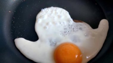 Tavada yumurta pişirmek. Tavada kızarmış yumurta. Basit bir lezzetli yemek pişirme konsepti.