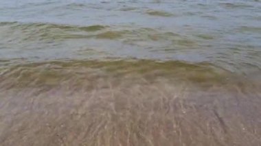 Dalgalar kumlu sahilde yuvarlanıyor. Yaz yüzme sezonu