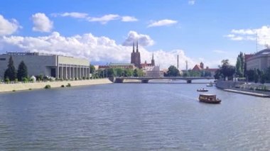 Wroclaw, Polonya, 15 Haziran 2022: şehir merkezindeki Odra nehrinde gemiler yüzüyor. Arabalar köprüden geçer. Güneşli açık bir gün